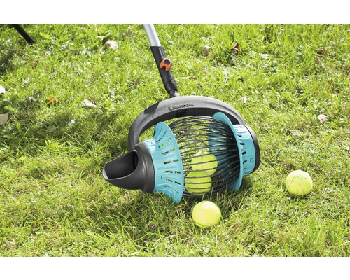 Sběrač míčů Gardena v akci na trávníku s tenisovými míčky.