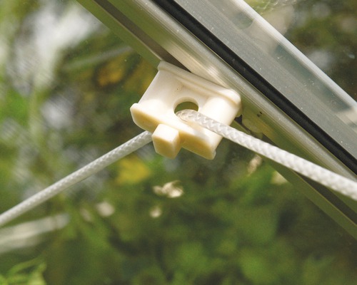 Detailní záběr plastového držáku se šňůrou na skleníku