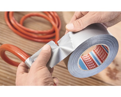 Osoba opravuje hadici lepicí páskou. Logo Tesa.