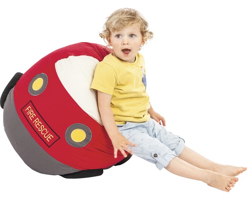 Dítě sedí na sedacím vaku ve tvaru hasičského auta.