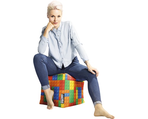 Žena sedí na sedací kostce s designem stavebních bloků