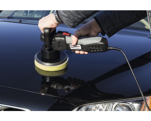 Osoba leští auto pomocí leštičky.
