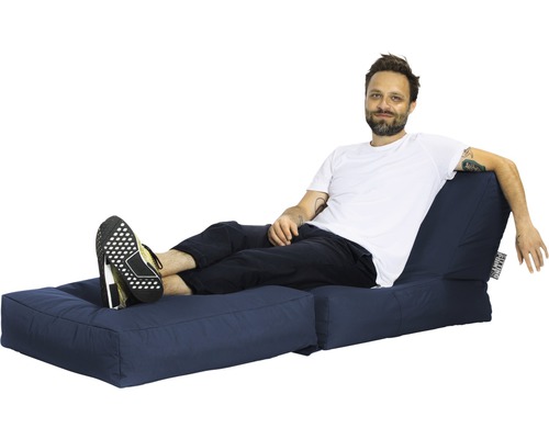 Muž odpočívá na modré zahradní pohovce.