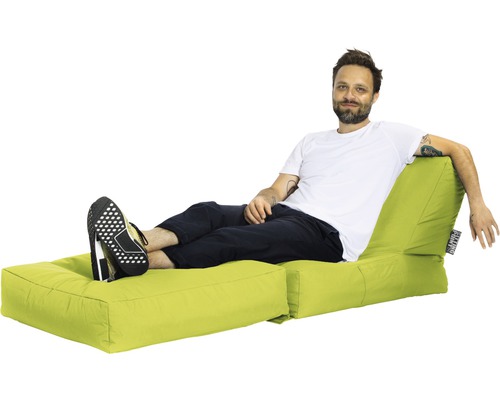 Muž odpočívá na světlém sedacím vaku s podnožkou