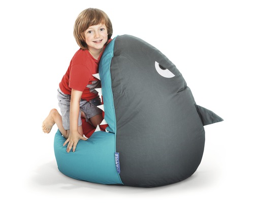 Chlapec leze na sedací vak ve tvaru žraloka.