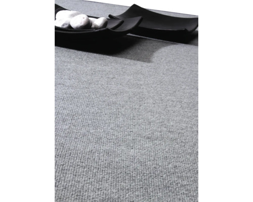 Šedý koberec s ozdobnou miskou a kameny