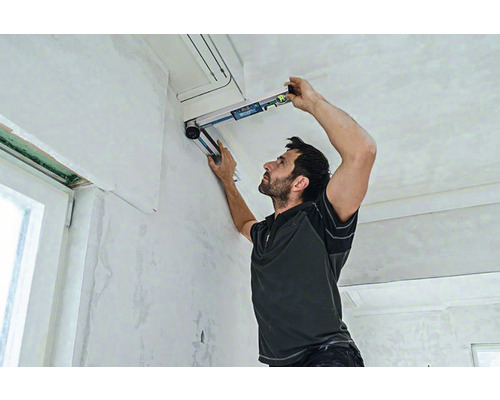 Muž používá vodováhu pro renovaci interiéru.
