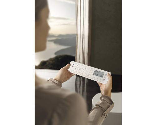 Žena drží systém domácí automatizace v koupelně.