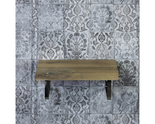 Dřevěná police s kovovými držáky před vzorovanou stěnou