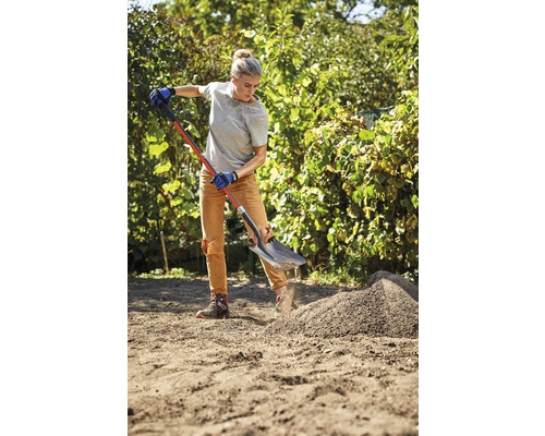Žena pracuje s rýčem na zahradě