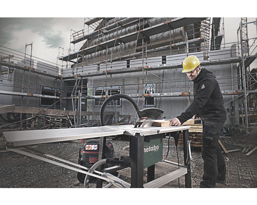 Řemeslník používá stolní kotoučovou pilu Metabo na staveništi.