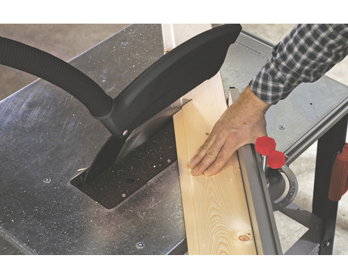 Stolní pila řeže dřevěnou desku.