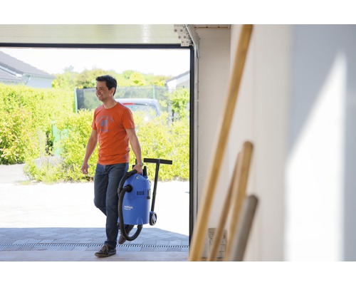 Muž transportuje mokrý a suchý vysavač z garáže