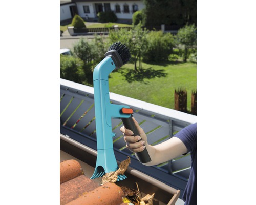 Osoba čistí okap čističem okapů