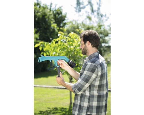 Muž obsluhuje teleskopický čisticí kartáč pro venkovní použití