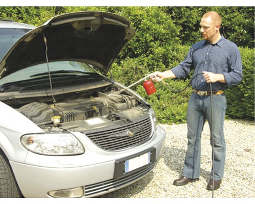 Muž čistí motorový prostor auta čisticím prostředkem