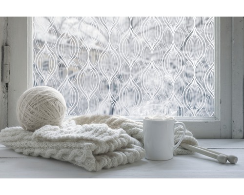 Dekorační fólie na okně s pletacími potřebami a nápojem