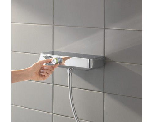 Nástěnná termostatická baterie se sprchovou hadicí na obložené stěně, nastavená teplota.