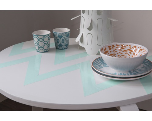 Prostřený kulatý stůl s nádobím a šálky