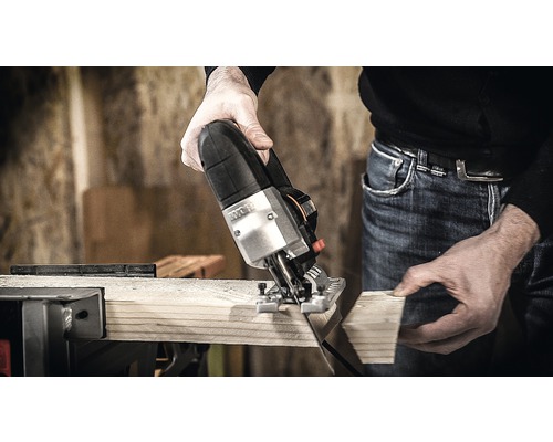 Přímočará pila řeže dřevěnou desku.