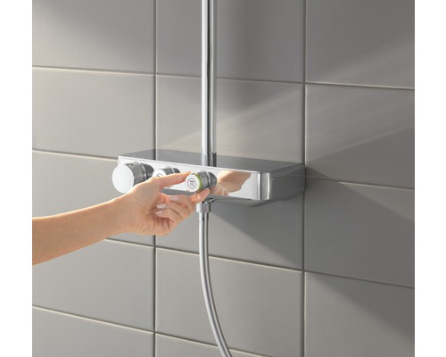 Nástěnná sprchová baterie s ručním ovládáním v koupelně.