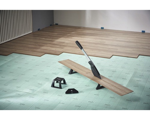 Řezačka laminátu používaná na izolační podložce s laminátovou podlahou v místnosti