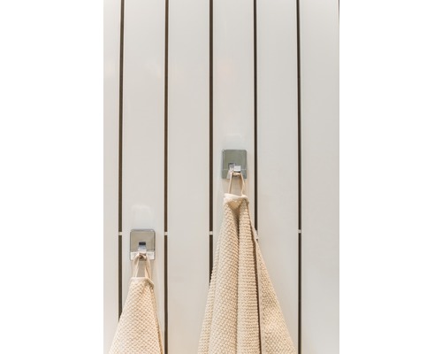 Dva ručníky visí na háčcích v koupelně