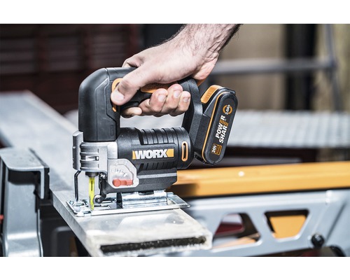 Akumulátorová přímočará pila v akci při řezání obrobku. Logo Worx.