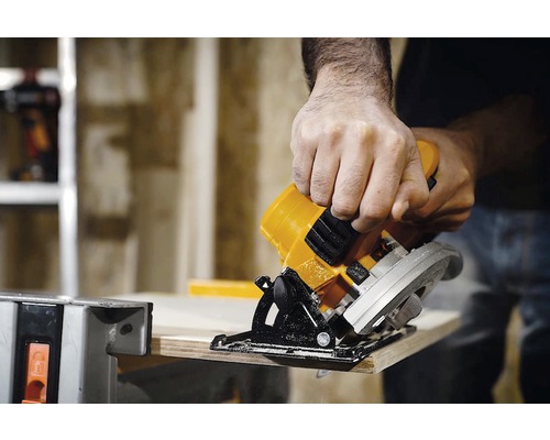 Ruční okružní pila řeže kus dřeva.