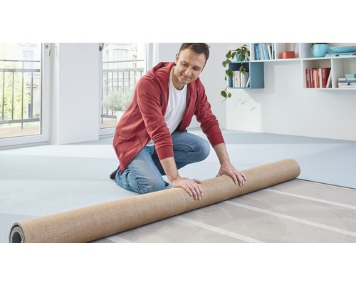 Muž pokládá koberec v interiéru