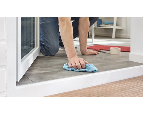 Muž čistí podlahové dlaždice hadrem