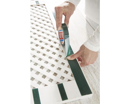 Aplikace oboustranné lepicí pásky Tesa na bílou dřevěnou mříž