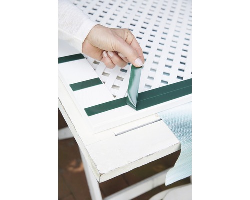 Osoba připevňuje proužky na ochranu soukromí k plotovému dílu