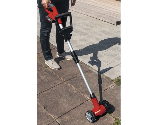 Osoba obsluhuje akumulátorový čistič spár na dlažebních kostkách