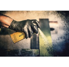 Ruka v ochranné rukavici používá akrylový sprej.