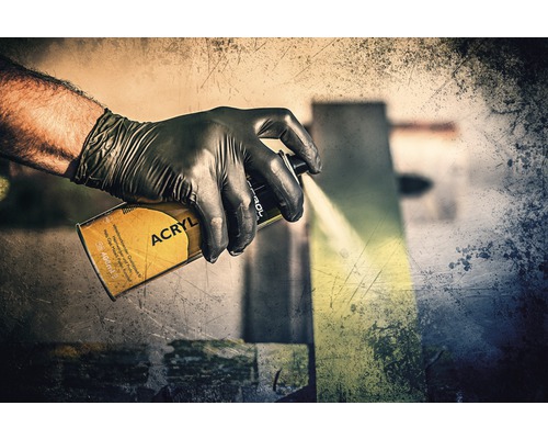 Ruka v ochranné rukavici používá akrylový sprej.