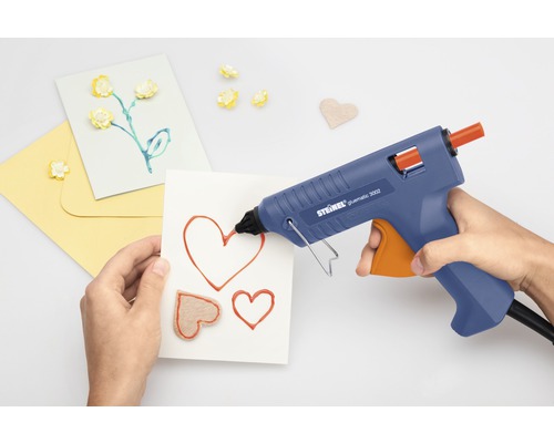 Osoba používá tavnou pistoli na výrobu přání