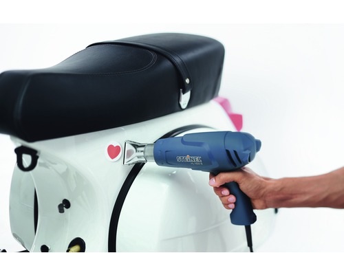 Horkovzdušná pistole při nanášení nálepky na skútr