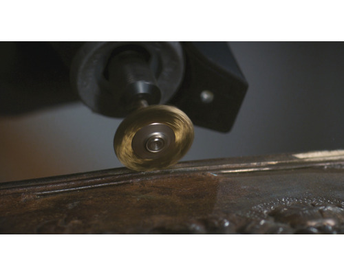 Rotační drátěný kartáč připevněný k multifunkčnímu nástroji pracujícímu na kovu