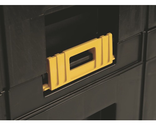 Detailní pohled na kufr na nářadí se žlutou rukojetí.