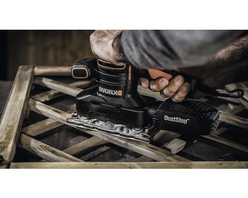 Osoba brousí dřevo vibrační bruskou WORX s odsáváním prachu
