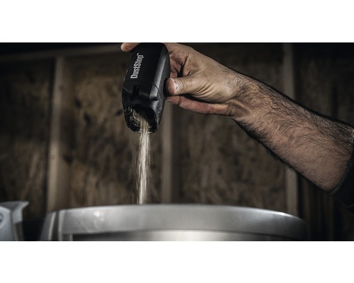 Ruka sype prach z nádoby na prach DustStop.