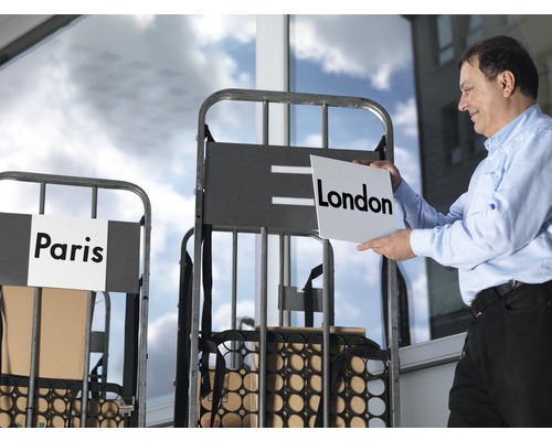 "Muž drží ceduli s nápisem Londýn před přepravním vozíkem