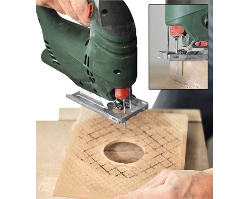 Přímočará pila vyřezává otvor do dřevěné desky.