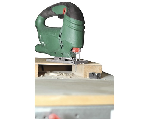 Zelená přímočará pila při řezání dřeva