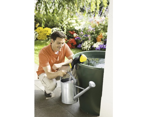 Muž plní konev s čerpadlem dešťové nádrže na zahradě