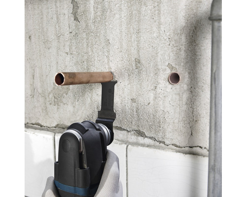 Multifunkční nástroj řeže měděnou trubku na zdi