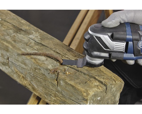 Multifunkční nástroj používaný k odstraňování hřebíku z dřevěného trámu