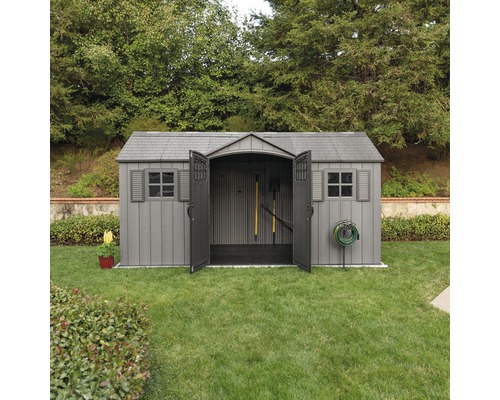 Zahradní kůlna s otevřenými dveřmi na trávníku