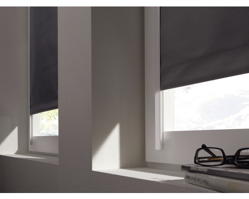 Dvě okna se šedými roletami, které jsou částečně zavřené